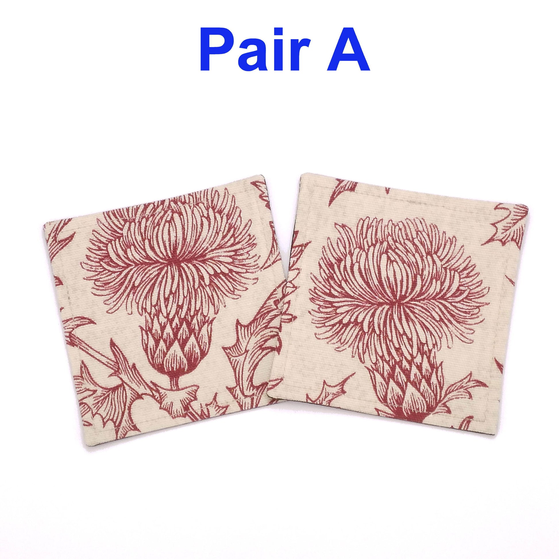 Square coasters with red thistle design on off-white background