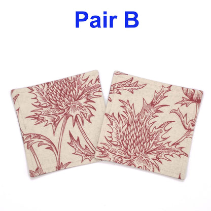 Square coasters with red thistle design on off-white background