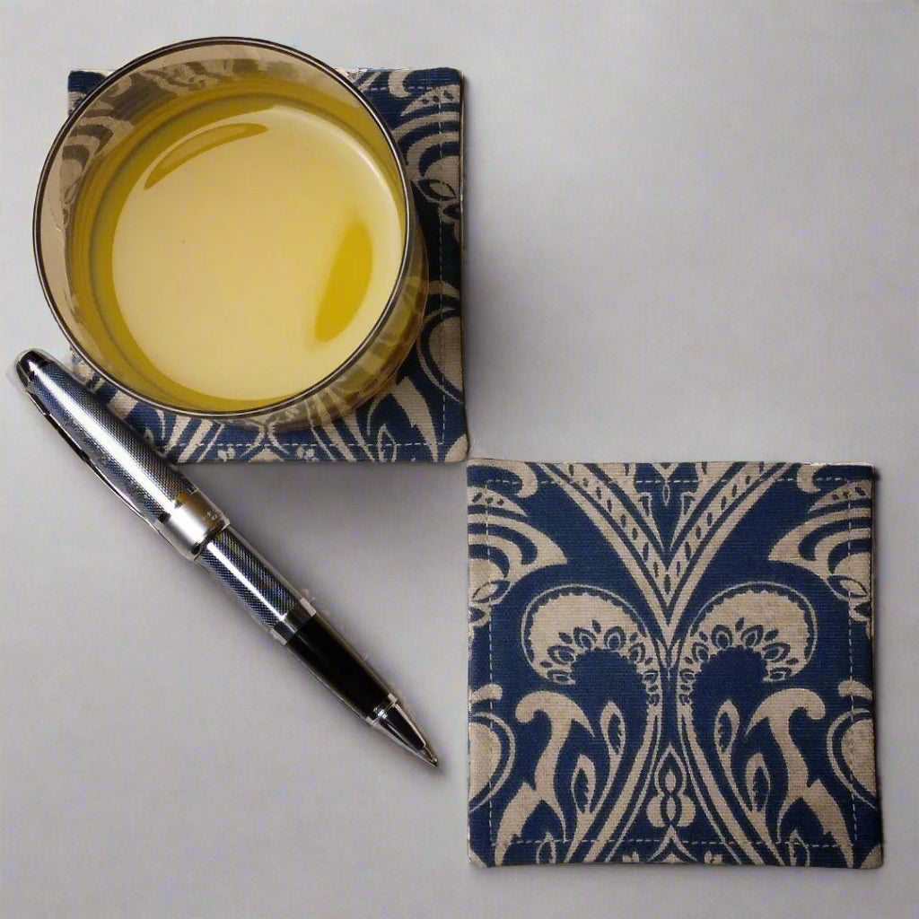 Square coasters with tan damask print on blue background