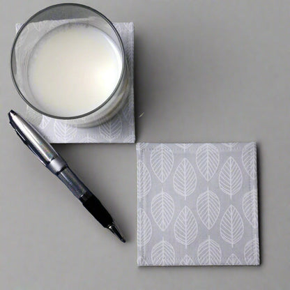 Square coasters with white leaf outline on grey background