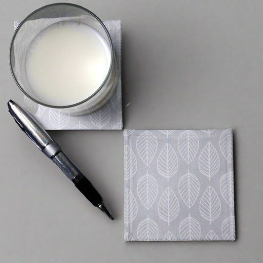 Square coasters with white leaf outline on grey background