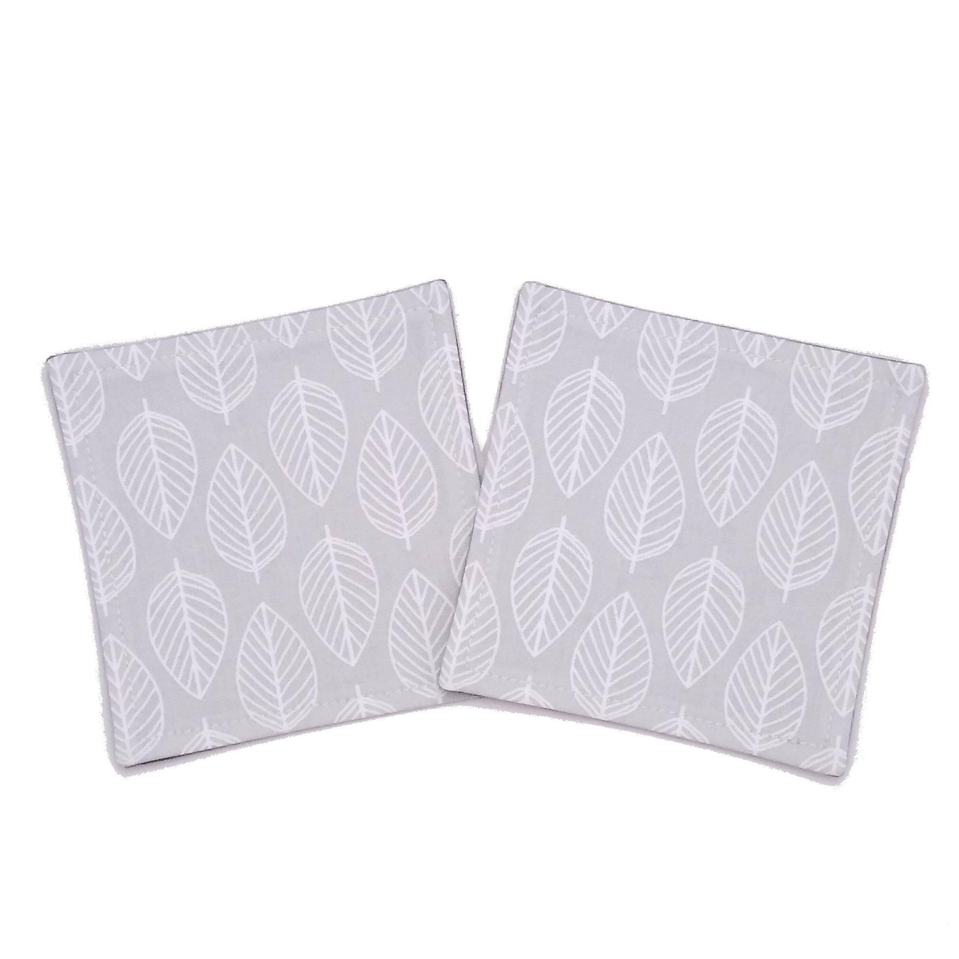 Square coasters with white leaf outline on grey background