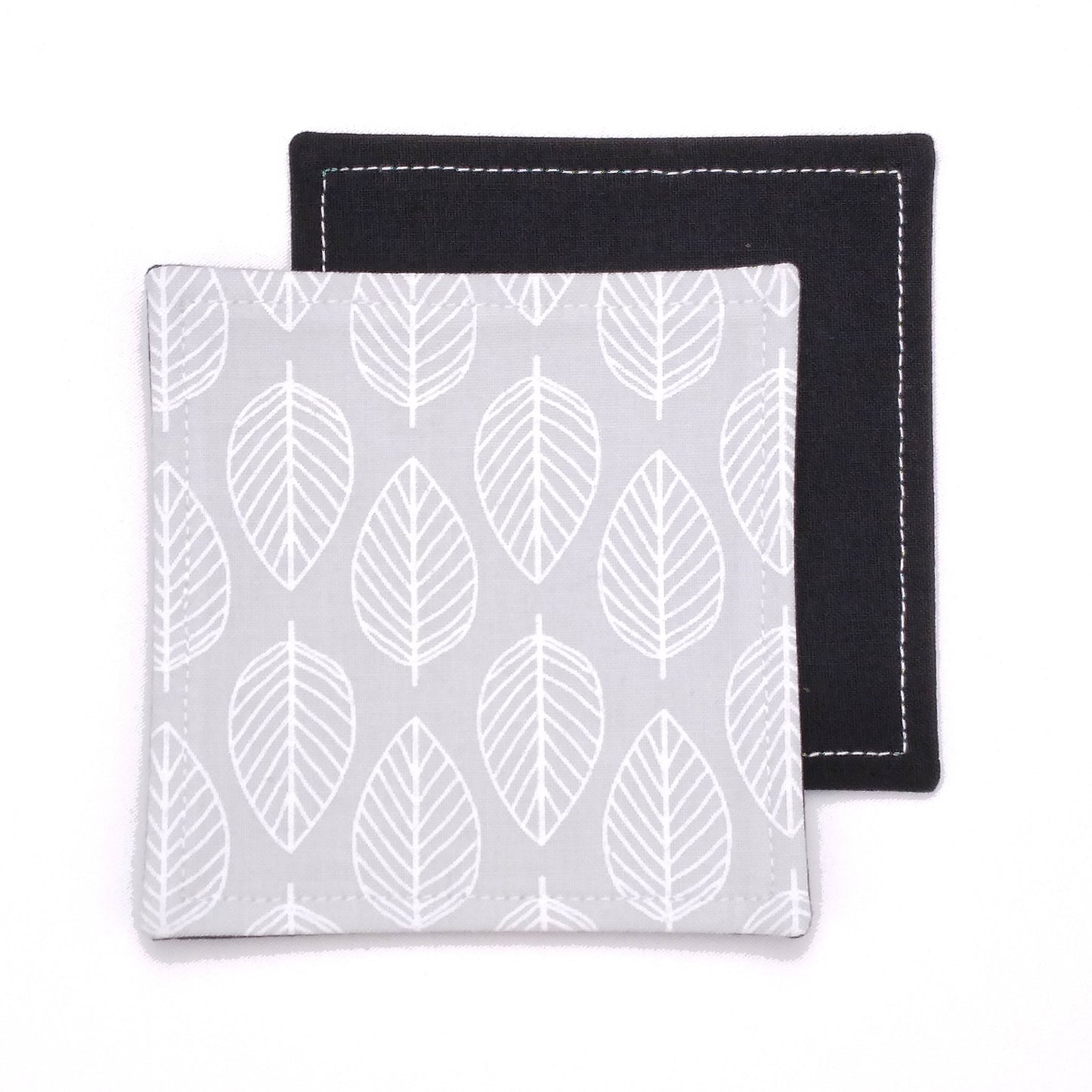 Square coasters with white leaf outline on grey background