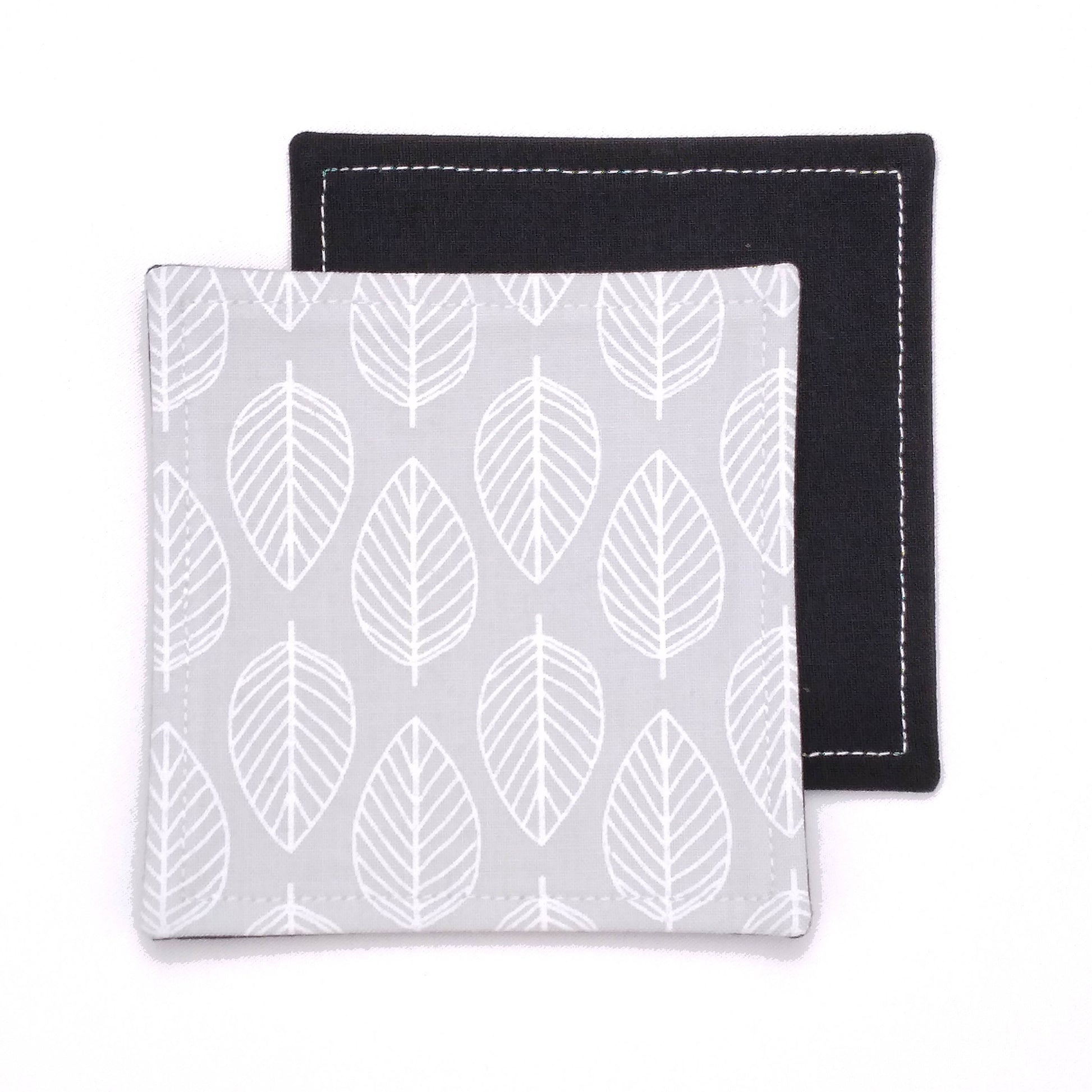 Square coasters with white leaf outline on grey background