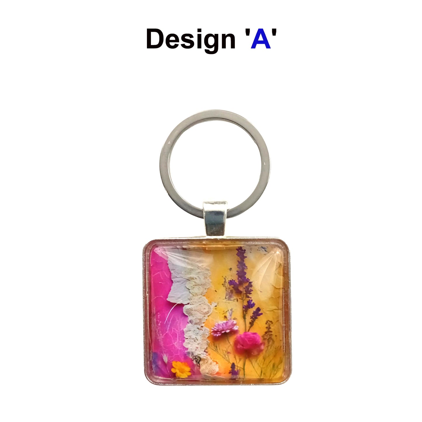A square glass cabochon keyring with colourful pink and yellow floral collage design in a metal frame with steel ring