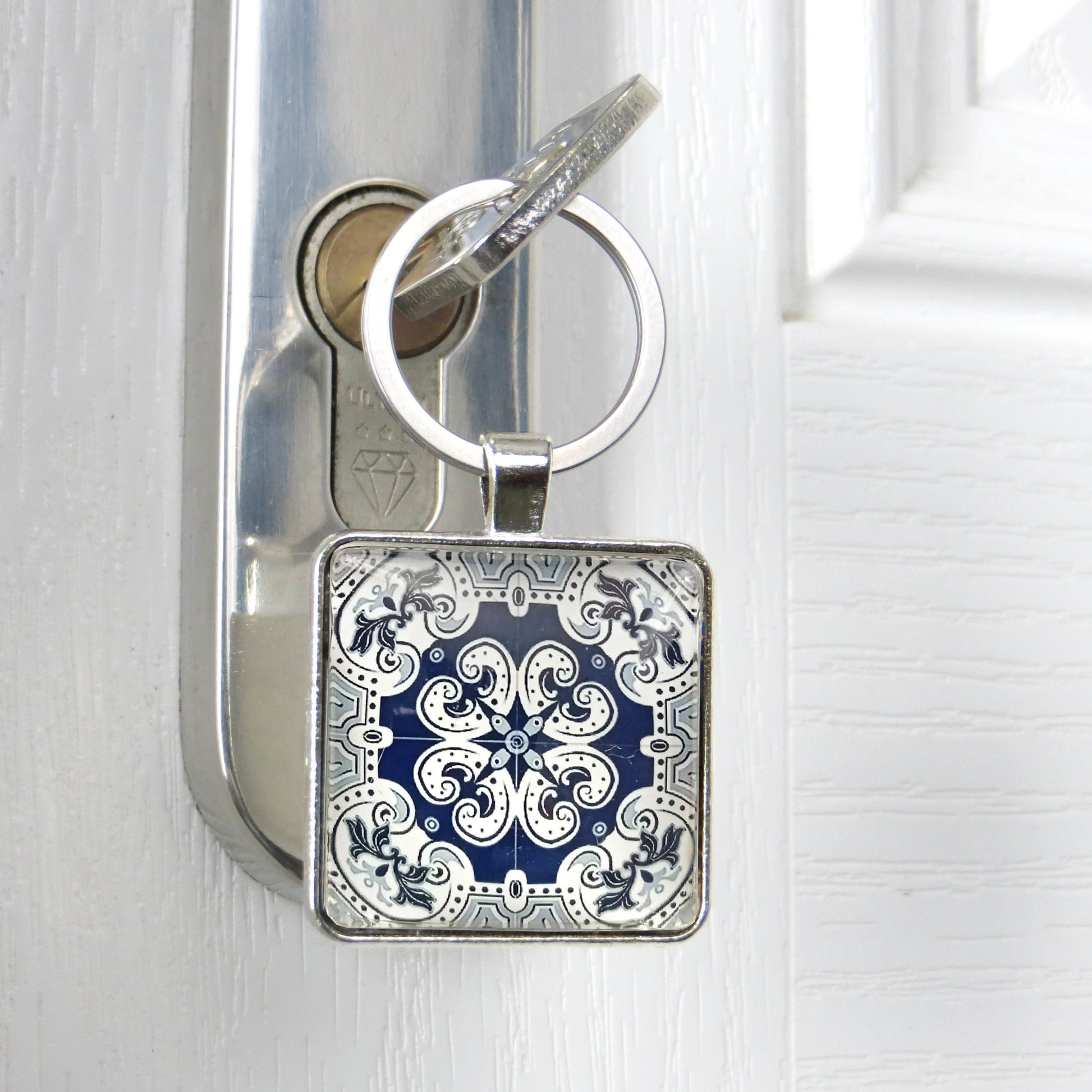Close up of a glass cabochon keyring with key in a door lock