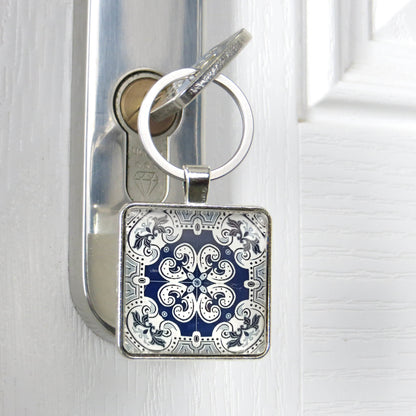 Close up of a glass cabochon keyring with key in a door lock