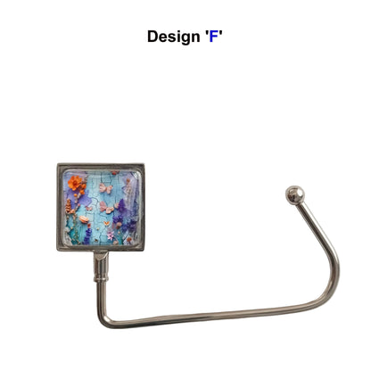 Handbag hook with glass cabochon and colourful blue and purple floral collage image, and metal hook