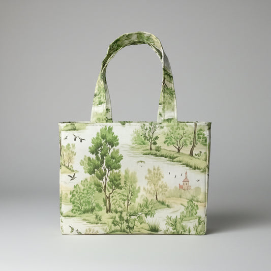A handmade mini cotton tote bag with a green and beige landscape toile pattern, featuring two top handles, photographed against a grey background.