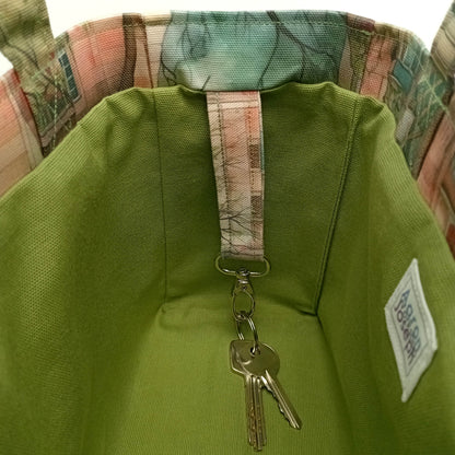 A close up of the metal key clasp with keys inside a handmade mini cotton tote bag with green lining.