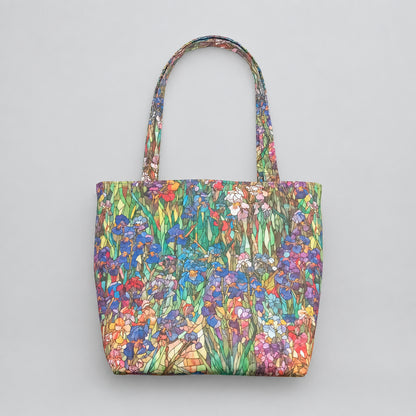 A large handmade cotton tote bag featuring a colourful print of irises and wildflowers, with shoulder straps.