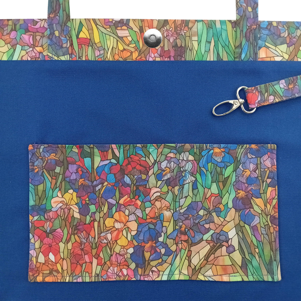 A handmade large cotton tote bag interior with a colourful floral print on the handles and matching slip pockets, featuring a metal key clip.