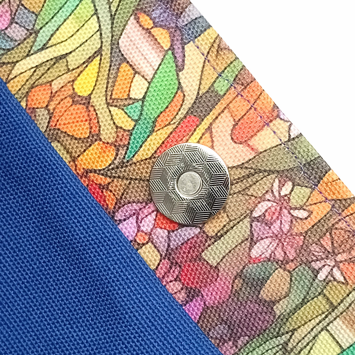 Close up of a handmade large cotton tote bag interior with a magnetic button, a blue interior, and colourful floral trim.