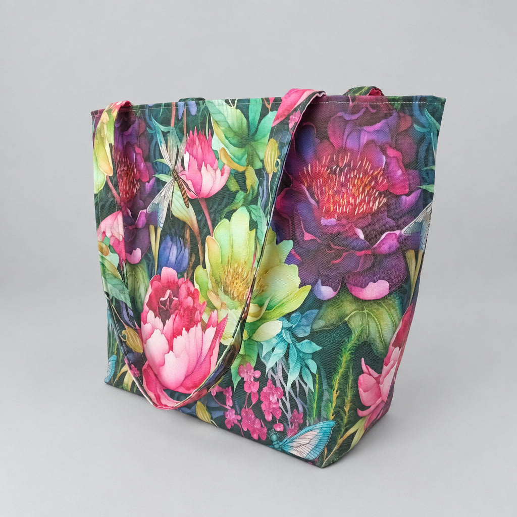 The reverse side of a large handmade cotton tote bag featuring a vibrant, dense botanical print with pink flowers, green leaves, purple blossoms, and dragonflies.