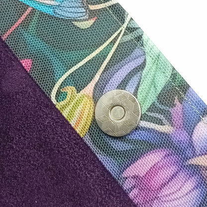Close-up of a handmade cotton tote bag interior with a dark purple velvet lining and a printed floral trim featuring a multicolour floral design, secured by a magnetic button closure.