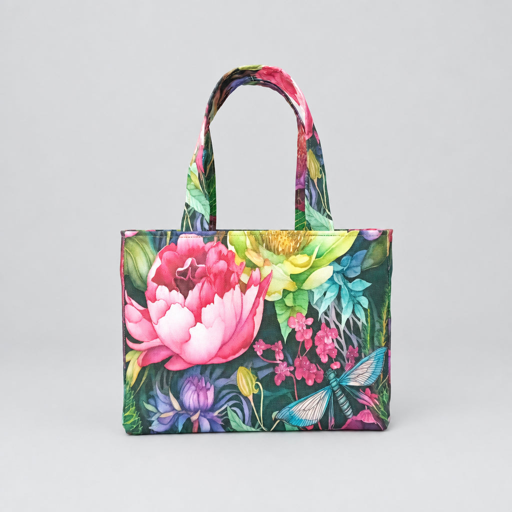 A handmade mini cotton tote bag with a vibrant, multicoloured floral print featuring a large pink peony, green leaves, and a dragonfly, and two top handles.