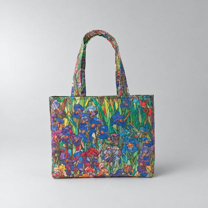 A handmade mini cotton tote bag featuring a vibrant stained-glass style floral print of irises in shades of blue, purple, red, green, and yellow, set against a light grey background.