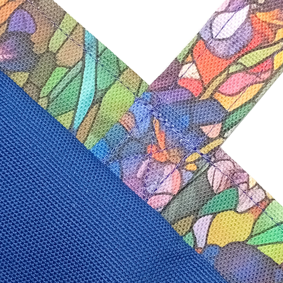 Close-up detail of a handmade mini cotton tote bag interior showing a blue cotton lining and a colourful stained-glass style trim.