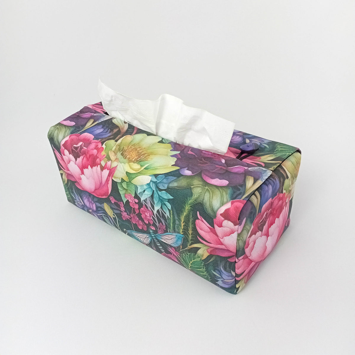 The reverse side of a handmade rectangular cotton tissue box cover with a vibrant multicolour floral print featuring pink, yellow, and purple flowers on a green background, with dragonflies.