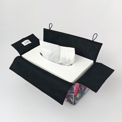 An interior view of a handmade rectangular cotton tissue box cover with a black lining and floral exterior.