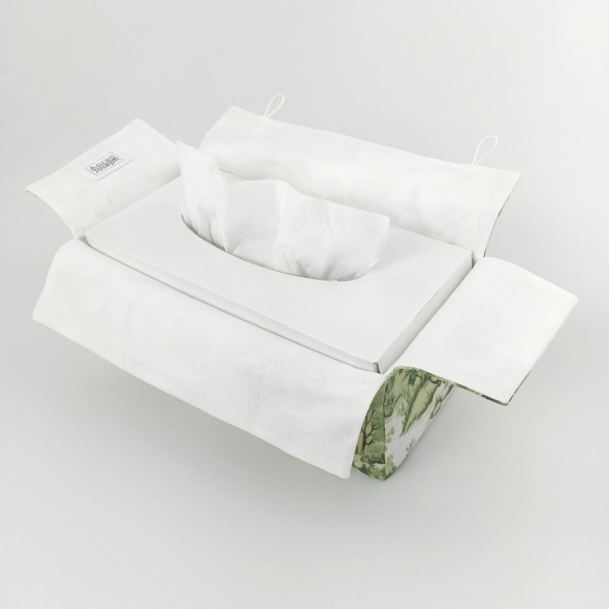 Interior view of a handmade cotton tissue box cover with a white interior and a green botanical pattern exterior.
