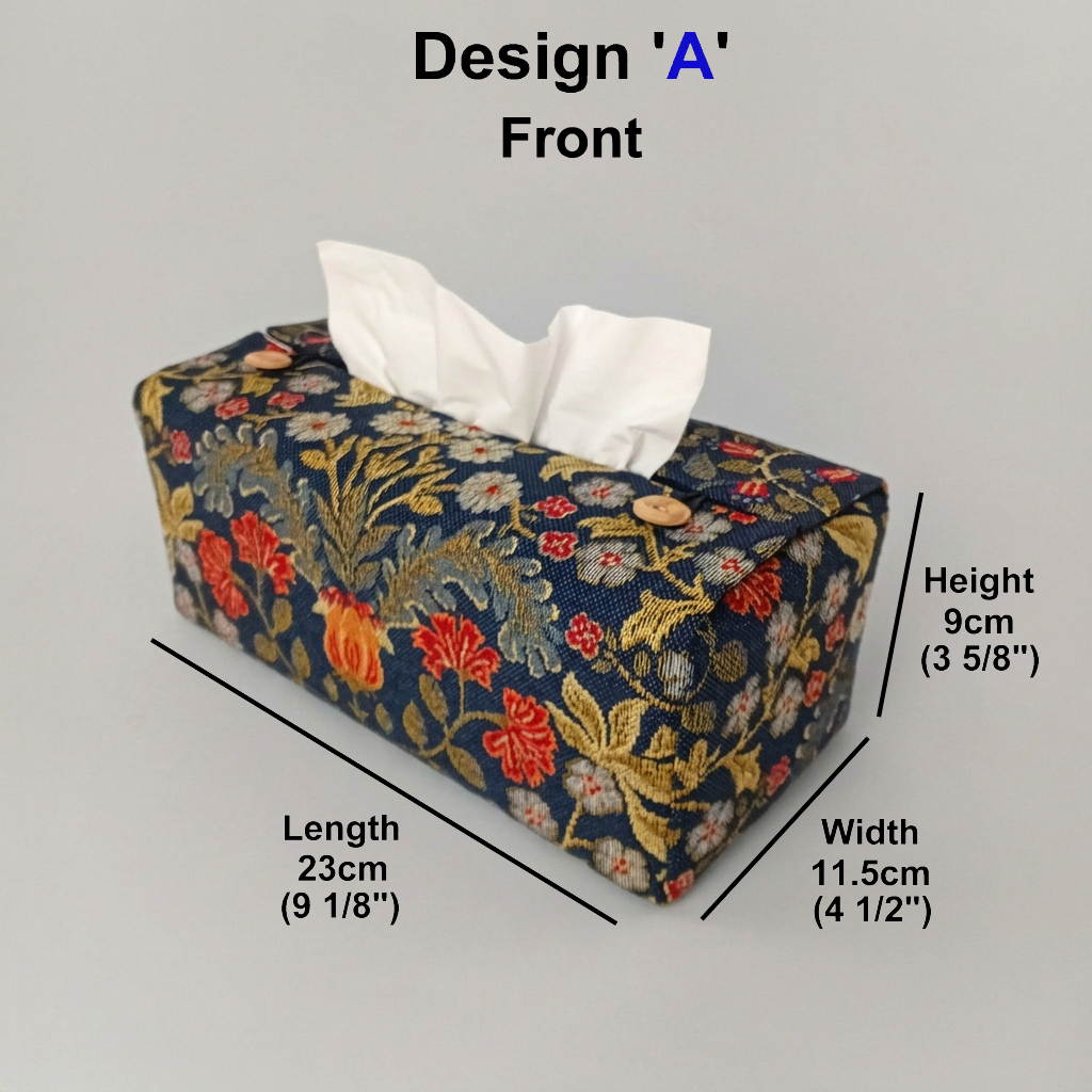 A handmade polycotton rectangular tissue box cover made of navy blue tapestry fabric with a colourful floral and botanical print in red, yellow, and green, with product measurements.