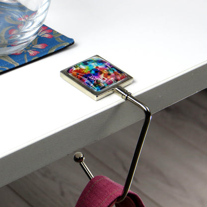 Handbag hook with glass domed image for hanging accessories on tables, ledges, and shelves