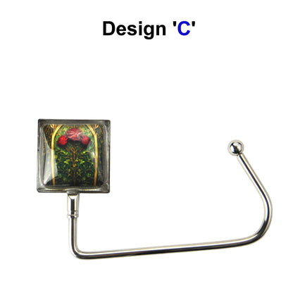 Handbag hook with glass domed image for hanging accessories on tables, ledges, and shelves