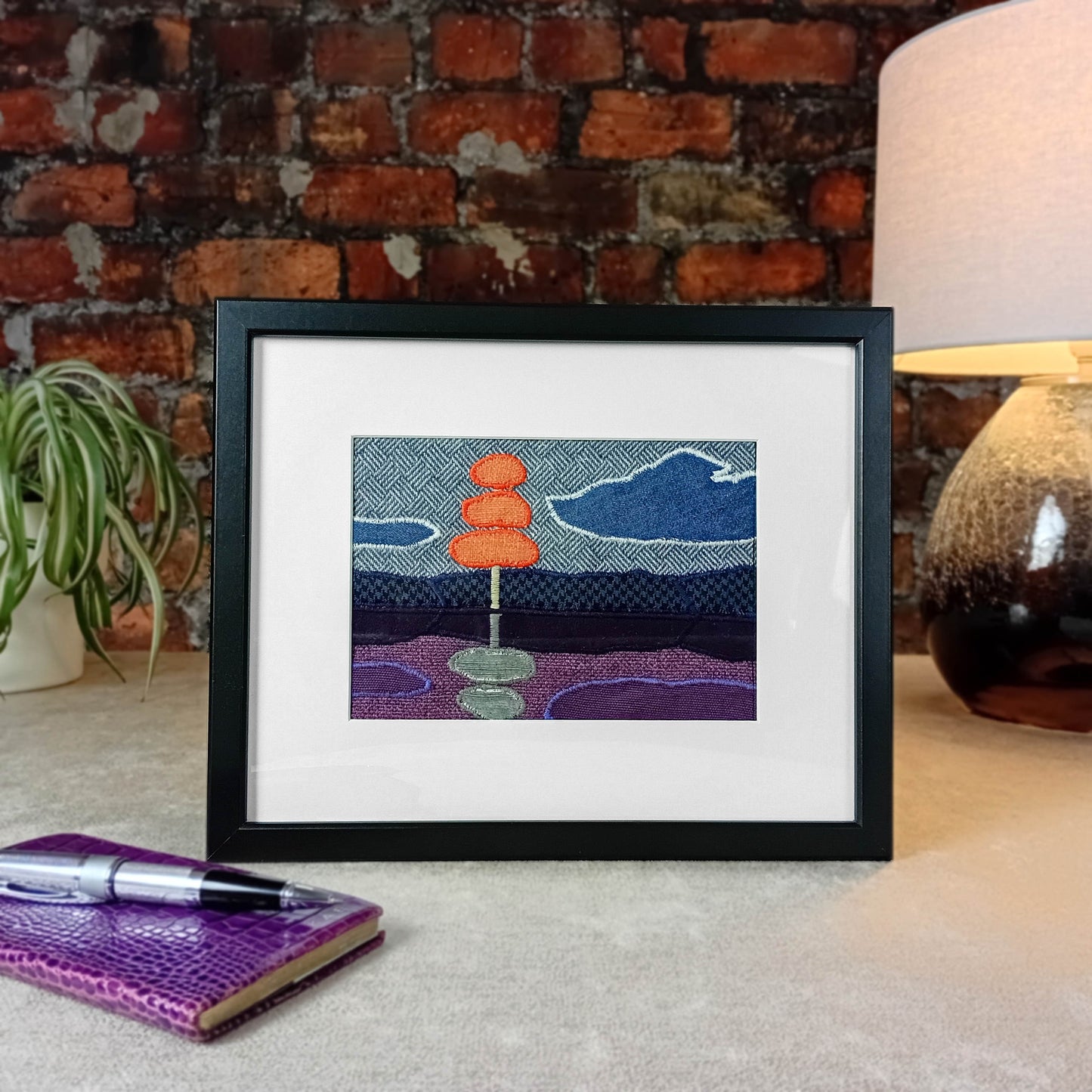 Framed fabric landscape scene with a stylised tree and lake