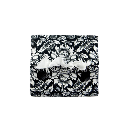 Square tissue box cover with white flowering vine design on black background