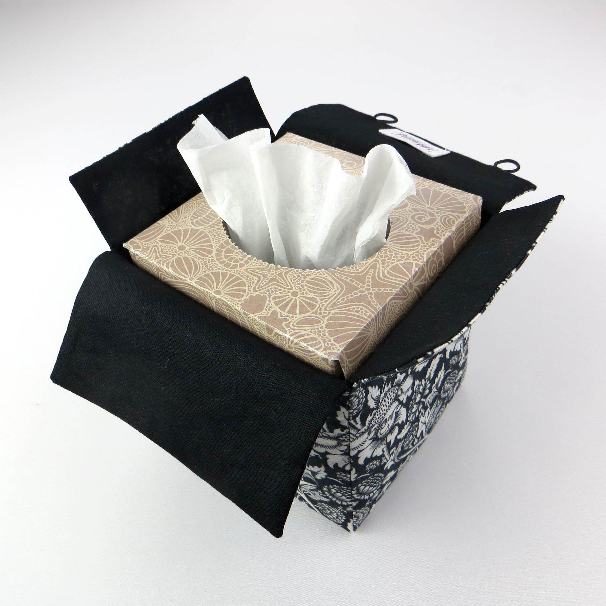 Square tissue box cover with white flowering vine design on black background