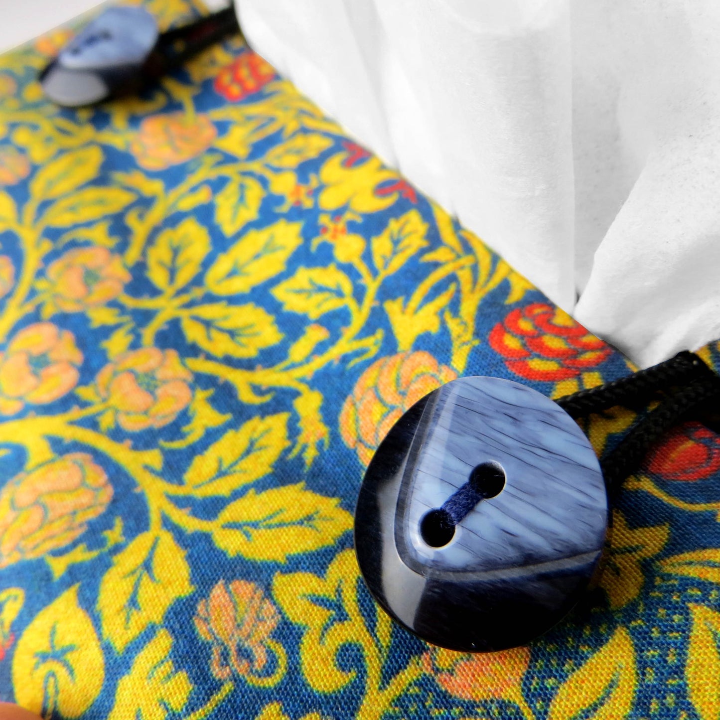 Cube tissue box cover with orange flowers and yellow vines design on blue background