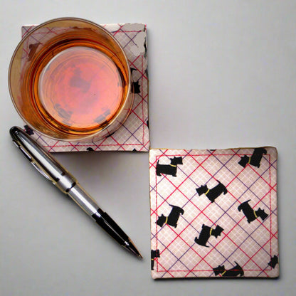Square coasters with Scottish Terrier dogs design on beige background with red, purple, and white grid