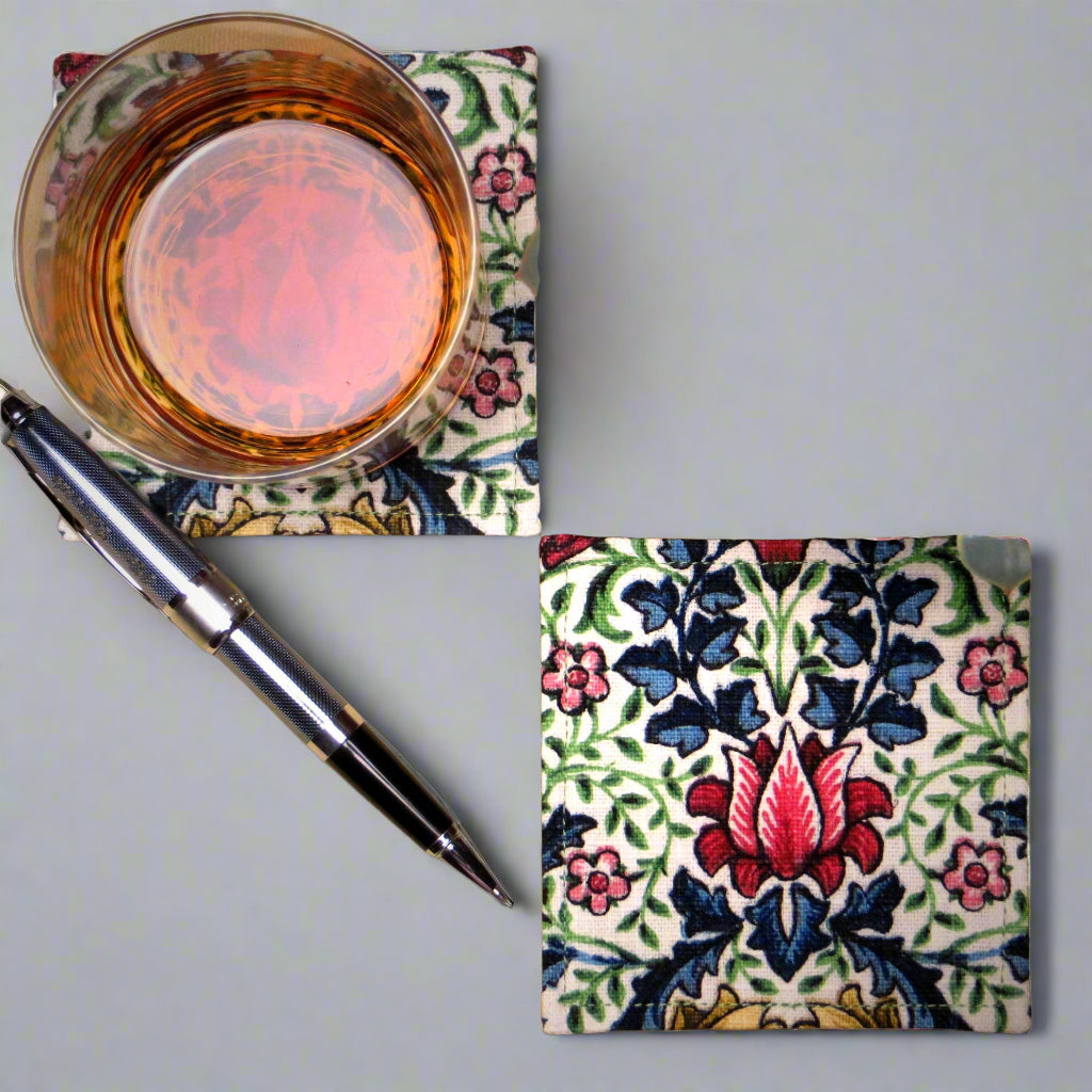 Square coasters with red, blue, green, and yellow flowers and leaves on off white background