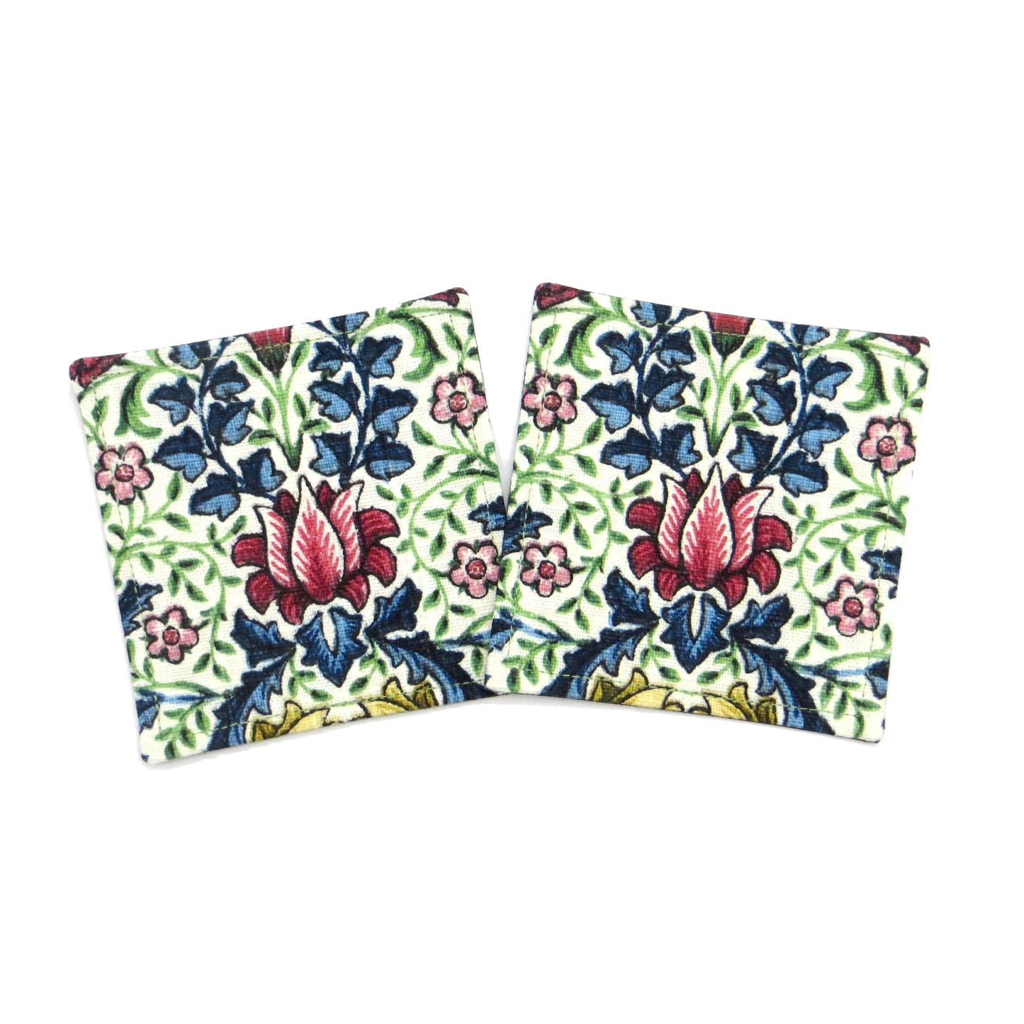 Square coasters with red, blue, green, and yellow flowers and leaves on off white background