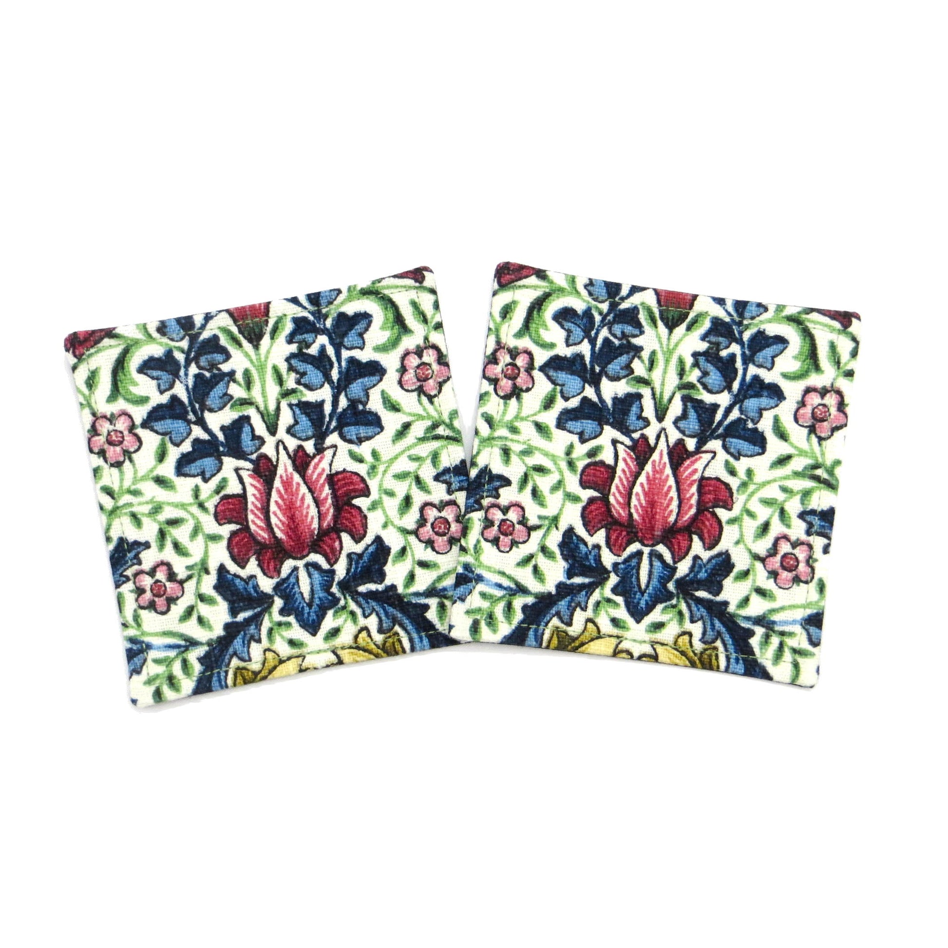 Square coasters with red, blue, green, and yellow flowers and leaves on off white background