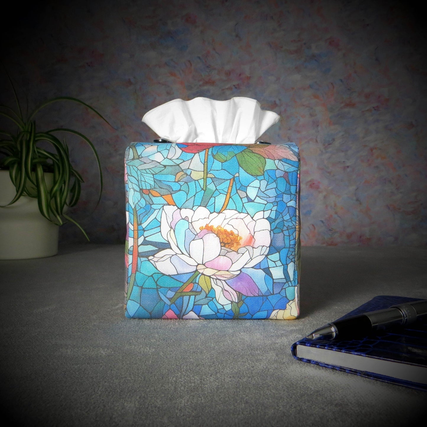 Square tissue box cover with pen, notebook, and plant
