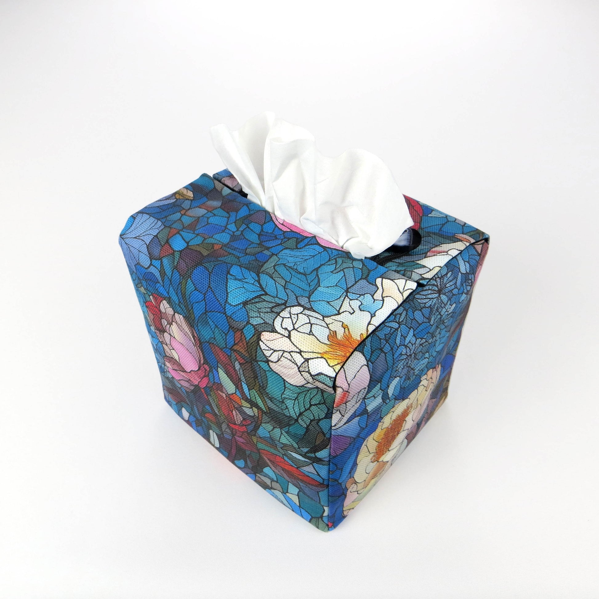 Back view of square tissue box cover with floral garden stained glass design on blue toned background