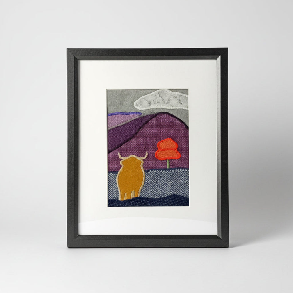 Framed fabric art with a highland cow and mountain image