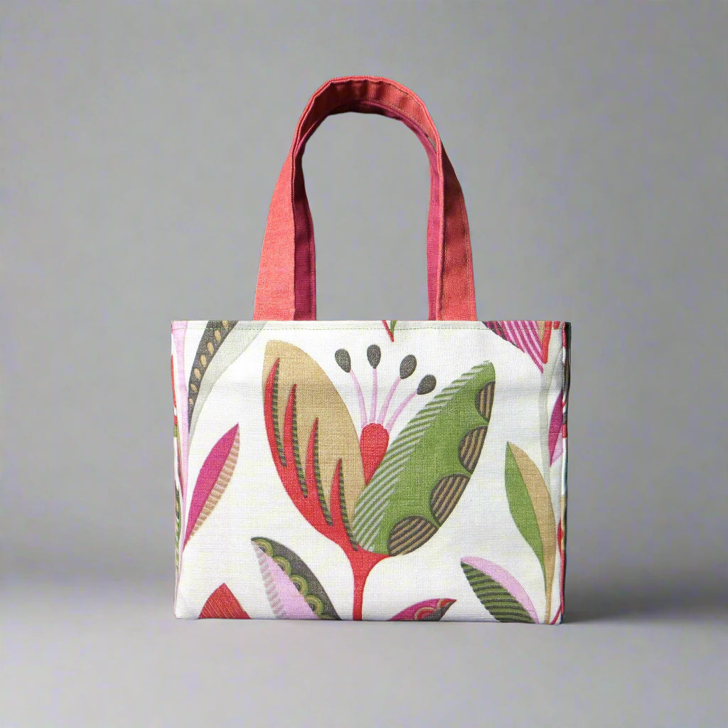 Small cotton tote bag with shades of moss green, raspberry pink, soft grey, and rhubarb red tulips on off-white background