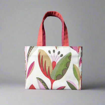 Small cotton tote bag with shades of moss green, raspberry pink, soft grey, and rhubarb red tulips on off-white background