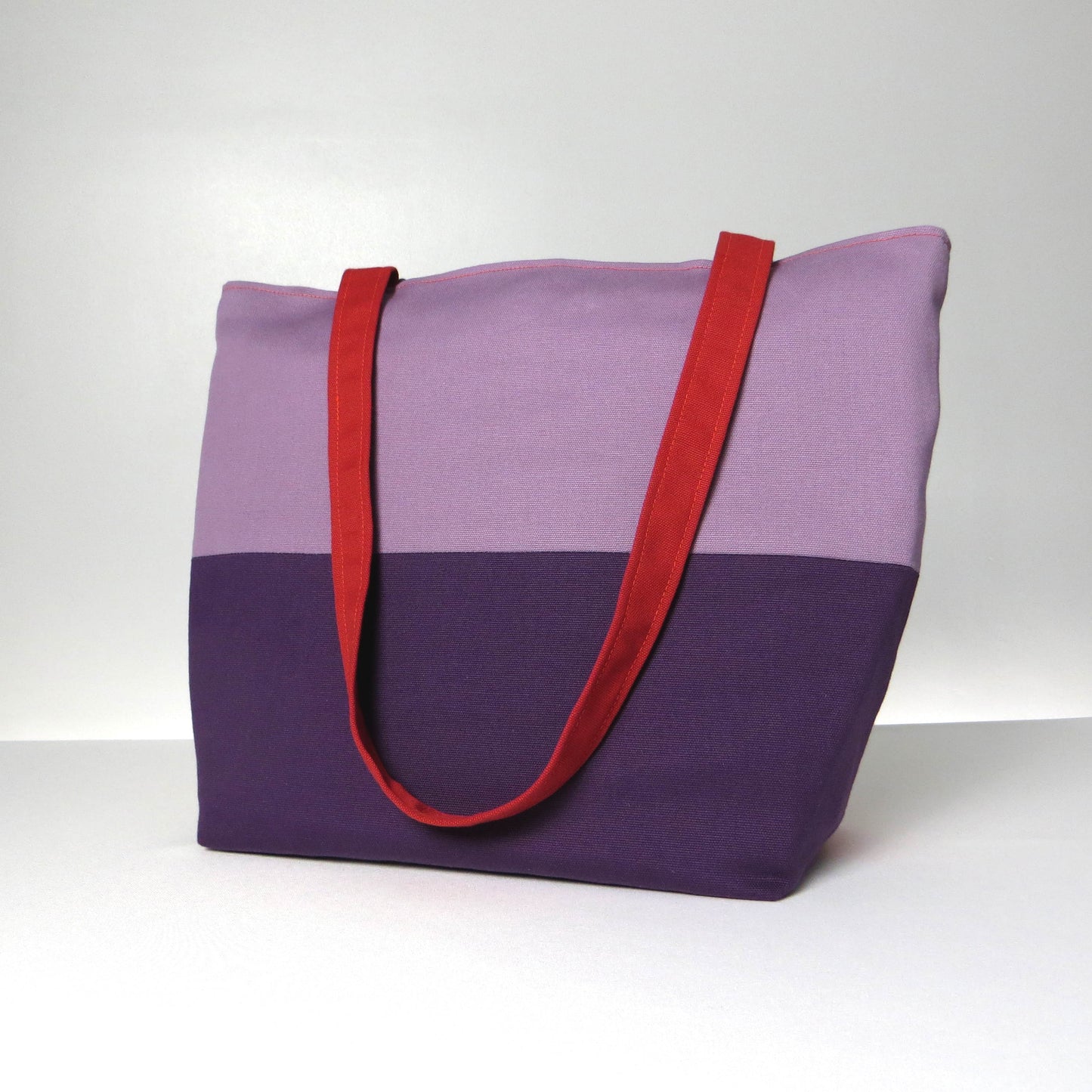 Side view of a large cotton tote bag with two vibrant colours on each side