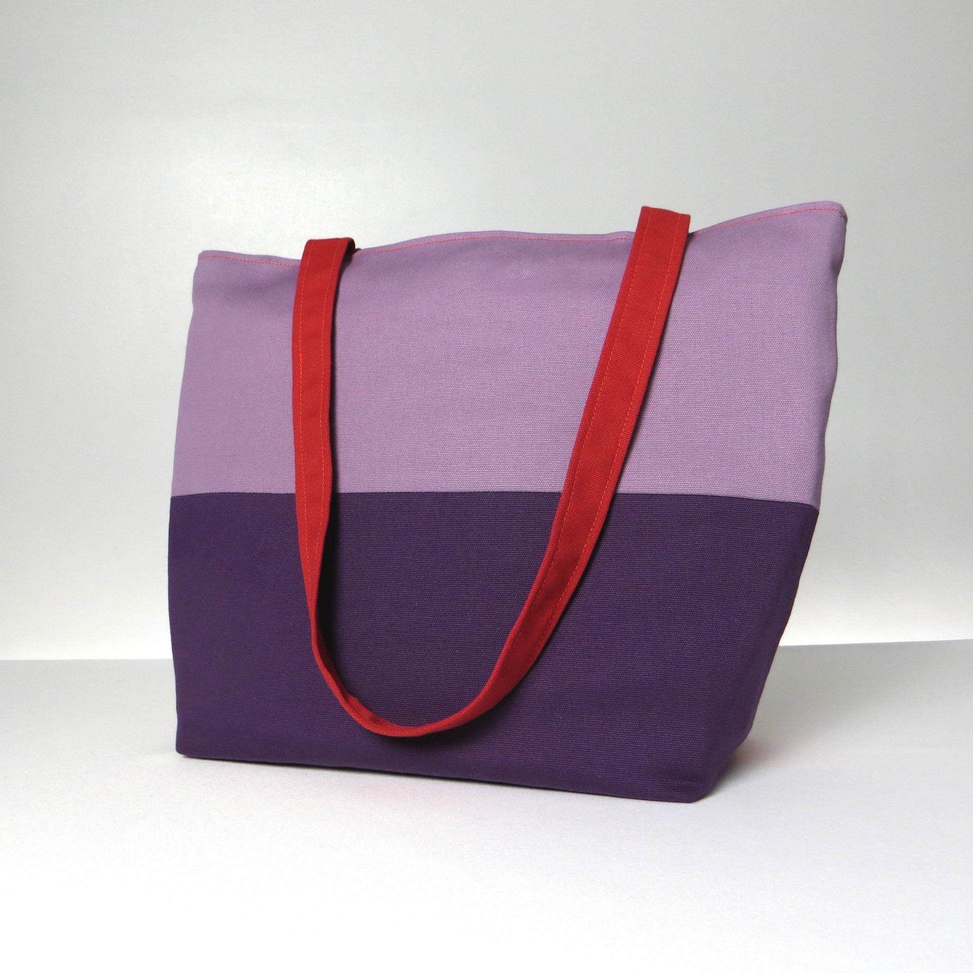 Side view of a large cotton tote bag with two vibrant colours on each side