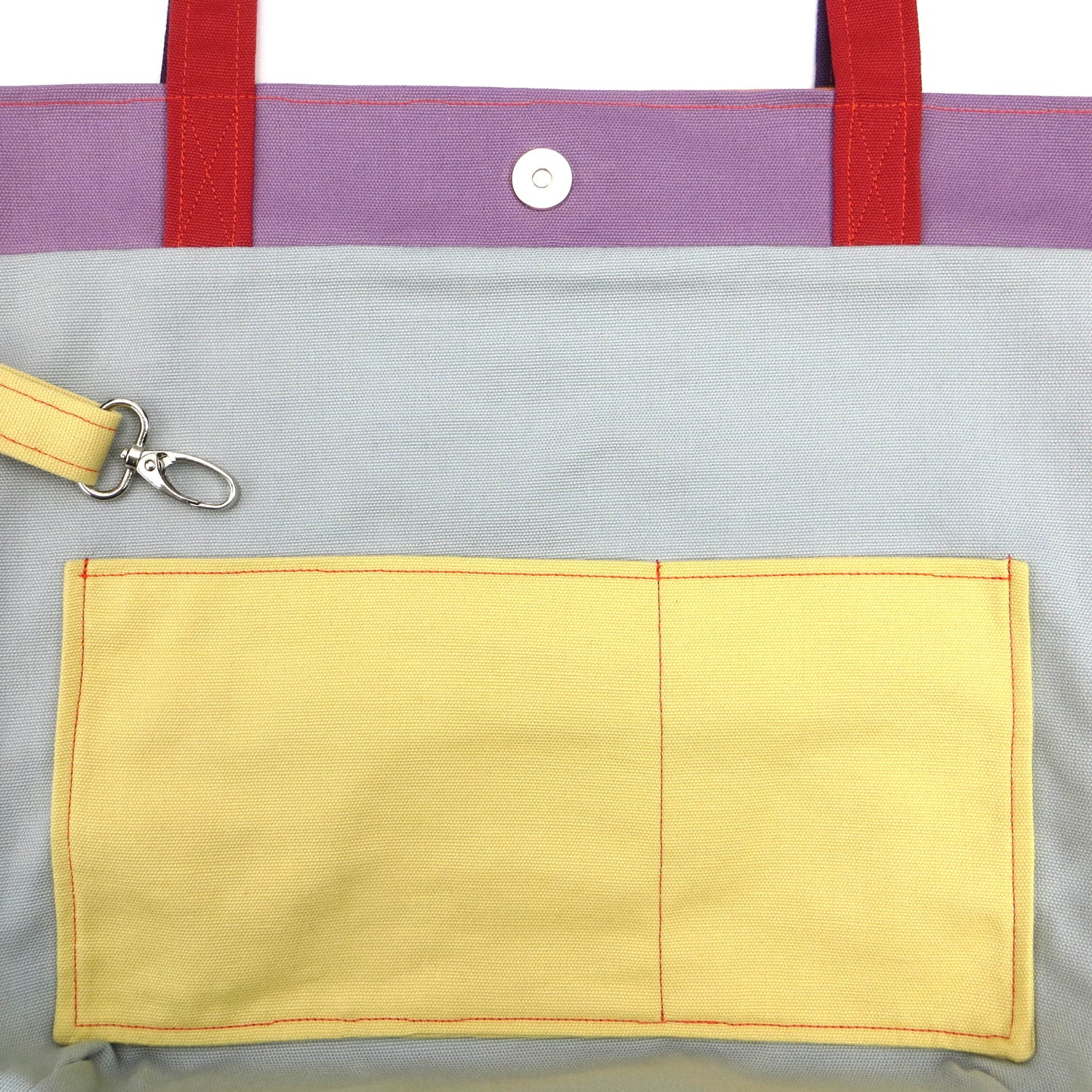 Close up view of a large tote bag interior slip pocket and key clasp