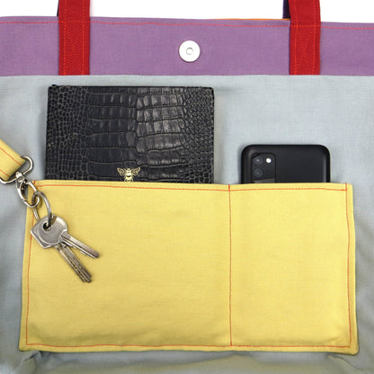 Close up view of a large tote bag interior slip pocket and key clasp