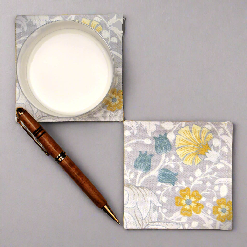 Set of 2 handmade coasters with white magnolia flowers and blue, yellow, and grey accents