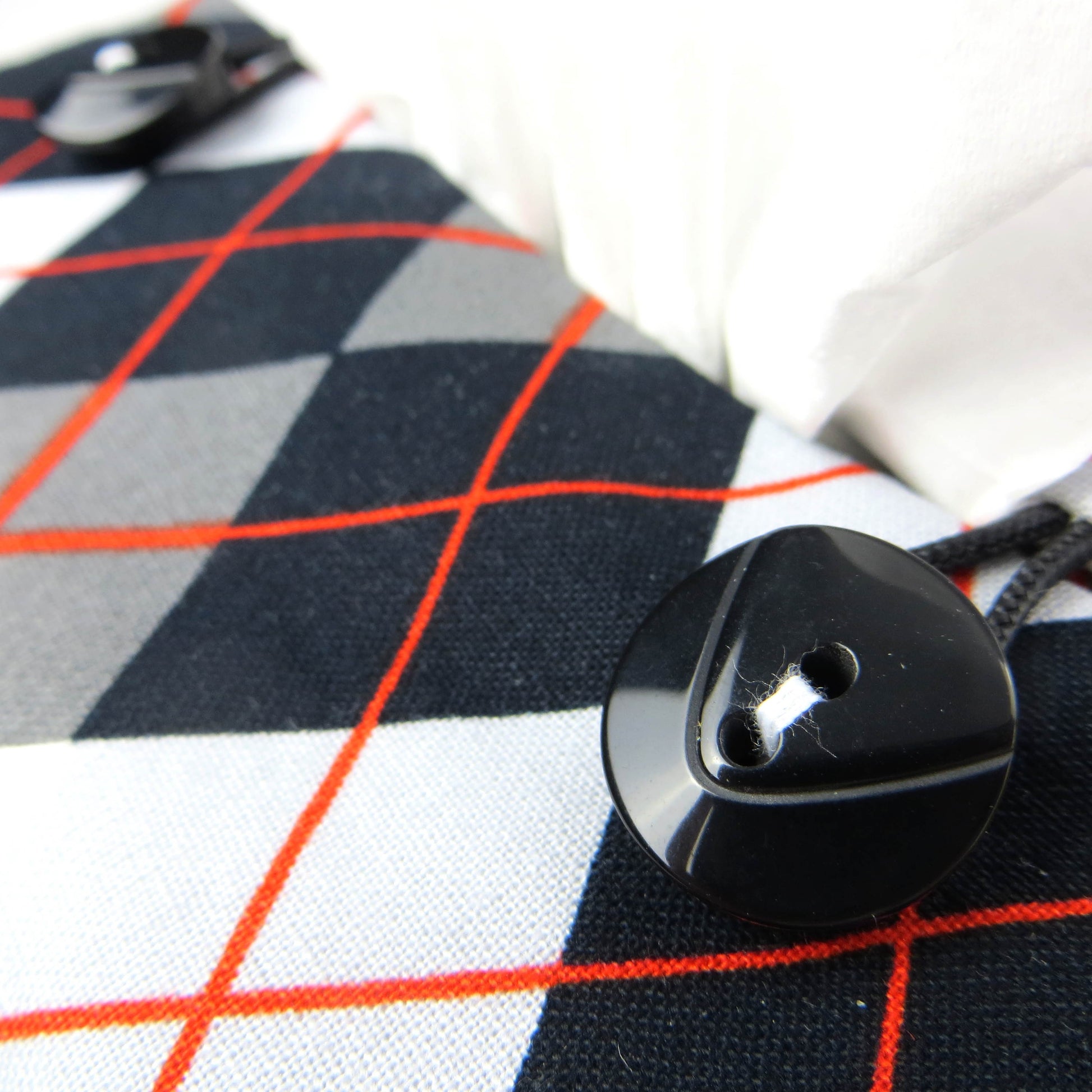 Square tissue box cover with black, grey, and red argyle pattern