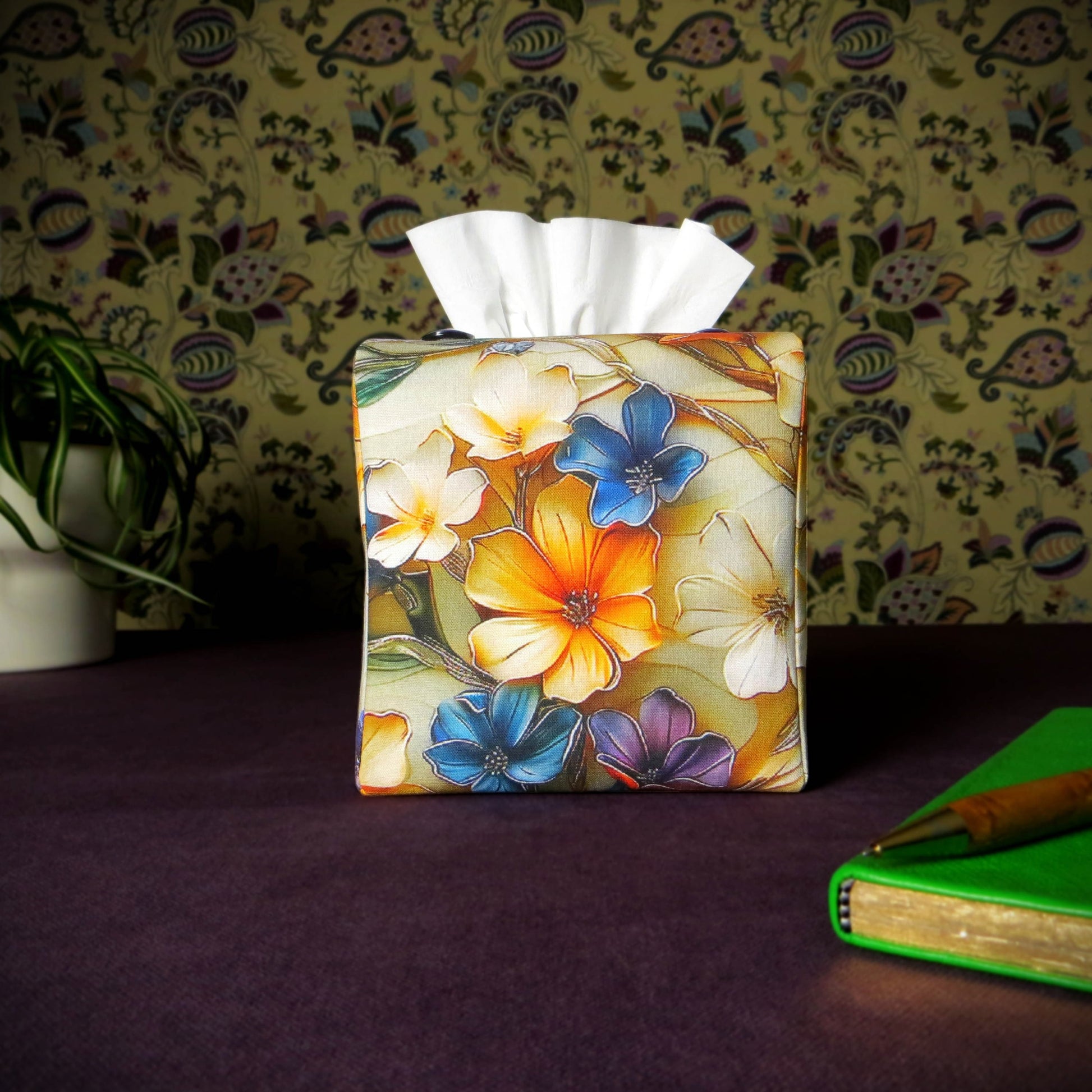 Square tissue box cover with pen, notebook, and plant