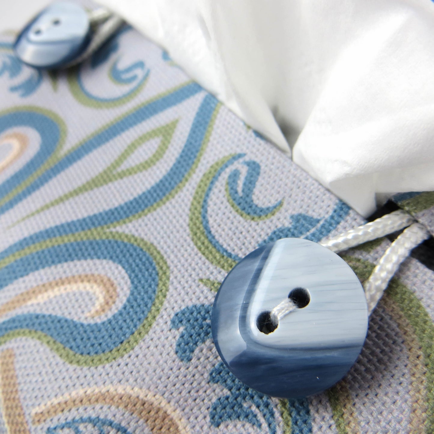 Square tissue box cover with charcoal grey and white flowers with blue, green and taupe Victorian embellishment on blue-grey background