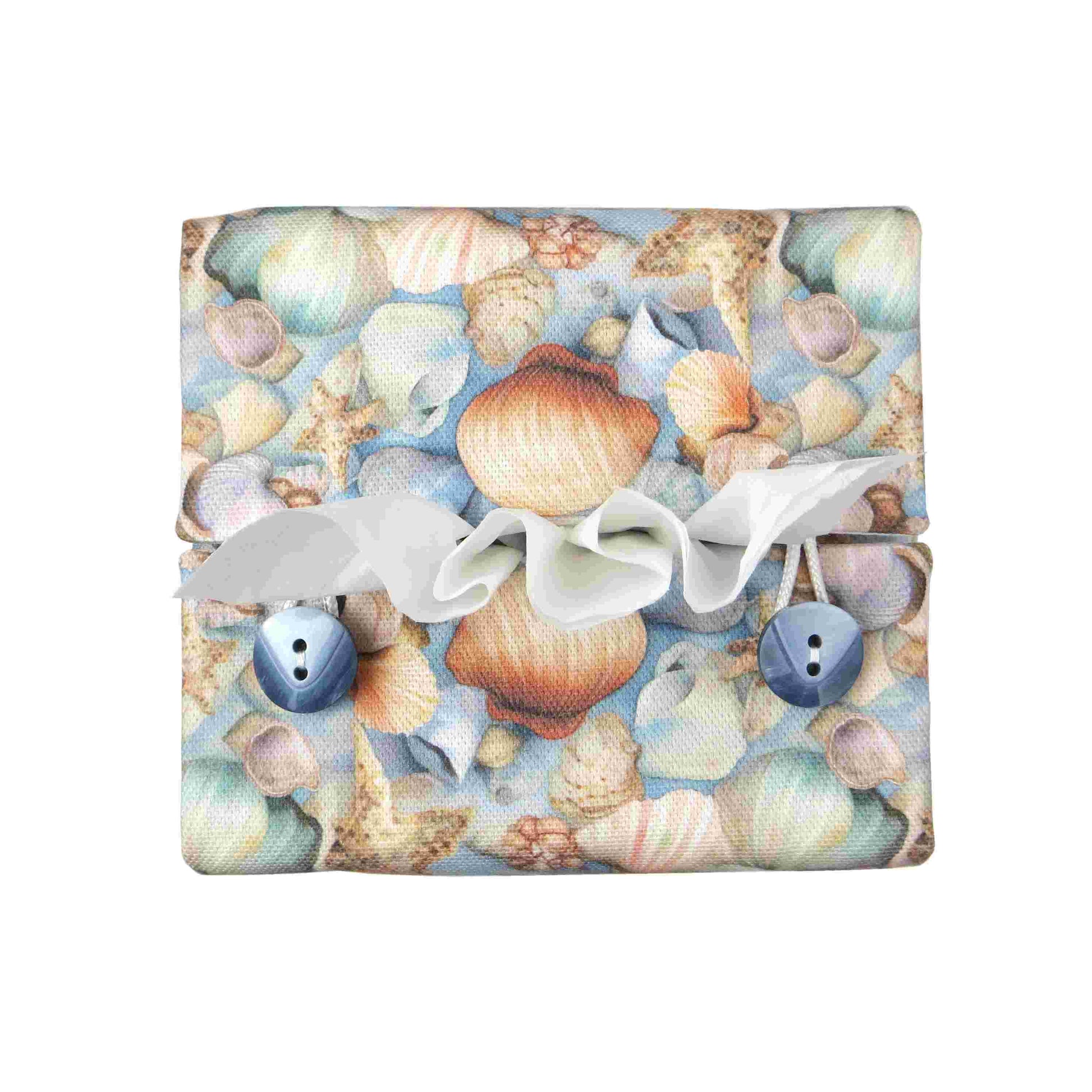 Cotton square tissue box cover with soft pastel seashell images set against a light blue background